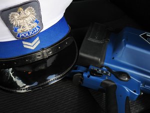 Na zdjęciu widoczna jest biała czapka policjanta ruchu drogowego oraz ręczny miernik prędkości
