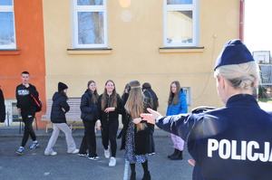 Policjantka odwrócona plecami oraz dzieci próbujące iść prosto w alkogoglach