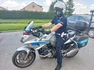 Policjant na parkingu siedzący na motocyklu