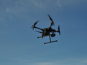 Na zdjęciu widoczny jest dron policyjny unoszący się w powietrzu