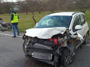 Na zdjęciu widoczny jest uszkodzony fiat. Z lewej strony znajduje się technik kryminalistyki.