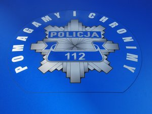 Na zdjęciu widoczna jest policyjna gwiazda z napisem 112 oraz Pomagamy i Chronimy