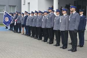 Mianowani policjanci stojący w dwuszeregu oraz poczet sztandarowy