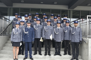 Stojący na schodach wejściowych do budynku komendy mianowani policjanci pozujący do zdjęcia