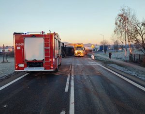 Droga na której widać wóz strażacki, wywrócony pojazd oraz pomoc drogową