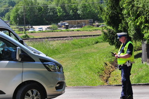 Policjant ruchu drogowego stojący przed zatrzymanym pojazdem