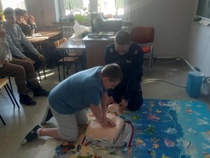 Jeden z uczniów podczas RKO na fantomie. Obok policjant