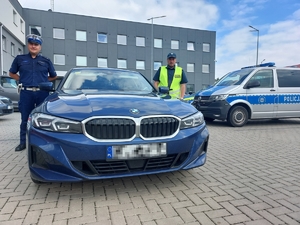 Nieoznakowany pojazd bmw. Obok stoi policjant oraz funkcjonariusz ITD