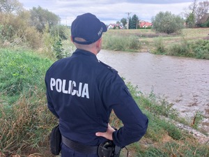 Policjant stojący na brzegu rzeki