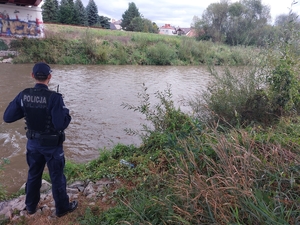 Policjant stojący nad brzegiem rzeki