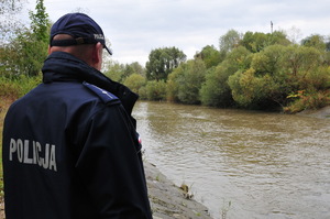 Policjant stojący nad brzegiem rzeki