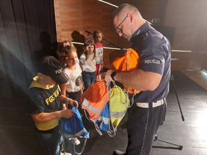 Policjant wręczający dzieciom nagrody