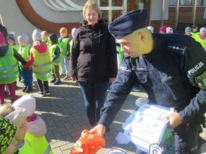 Policjant odbierający podziękowanie od dzieci