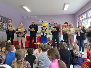 Policjanci wraz z pedagogami czytający dzieciom