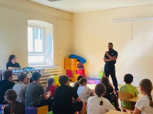 na zdjęciu widoczny policjant podczas prelekcji w szkole oraz dzieci i młodzież