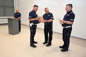 policjant odbierający nagrodę z rąk komendanta oraz naczelnika