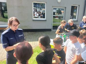 policjantka czytająca pytanie uczestnikom konkursu