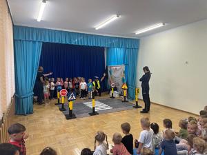 Policjanci w szkole mówiący do zebranych dzieci