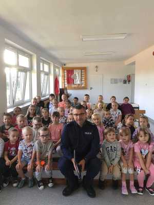 Policjant siedzący wśród dzieci
