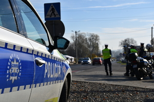 Bok radiowozu przy drodze do cmentarza