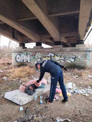 Dzielnicowy pochylający się nad leżącym mężczyzną