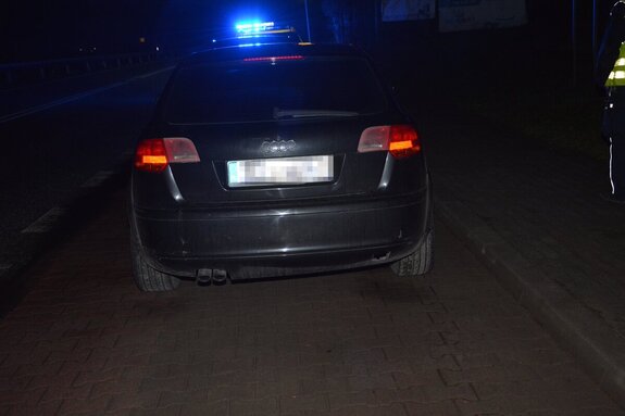 Tył Audi, w tle niebieskie światła radiowozu