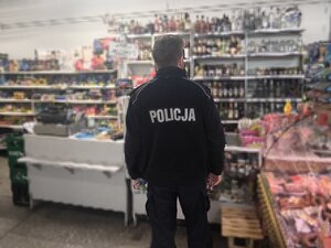 Dzielnicowy podczas działań wewnątrz sklepu