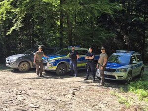 Policjanci i strażnicy na tle pojazdów służbowych