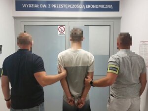 Policjanci trzymający skutego mężczyznę