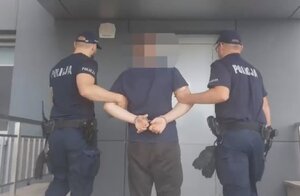 Policjanci prowadzą zatrzymanego mężczyznę