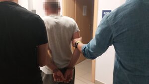Policjanci prowadzący zatrzymanego mężczyznę