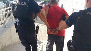 Policjanci prowadzący zatrzymanego mężczyznę